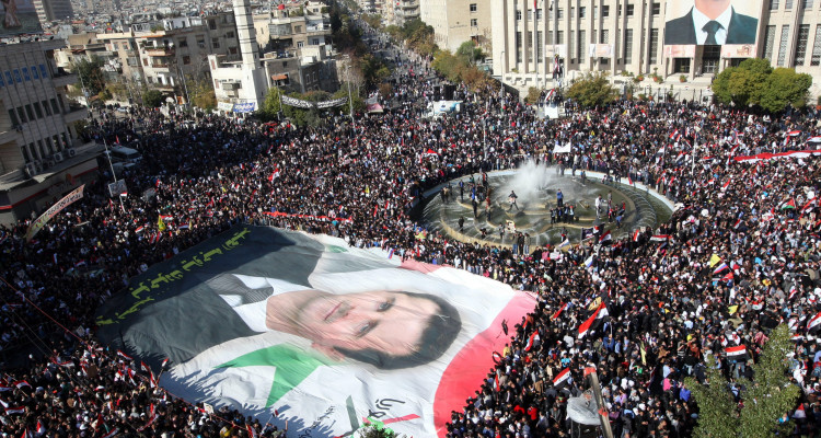 epa03017800 Syrian protesters display a giant portrait of President Bashar Assad during a pro-government rally at Sabe Bahrat square in downtown Damascus, Syria, 28 November 2011. According to media sources, thousands of supporters of Syrian President Bashar al-Assad rallied on 28 November across the country to protest the Arab League sanctions imposed on Damascus. Arab League foreign ministers endorsed on 27 November a package of economic sanctions against the Syrian government over its relentless clampdown against opposition. EPA/YOUSSEF BADAWI
